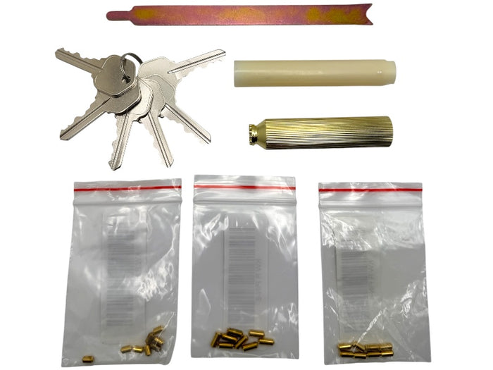 Set of keys, cylindrical objects, and small metal components on a white background