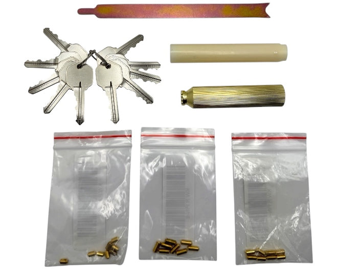 Set of keys, cylindrical objects, and small metal components on a white background