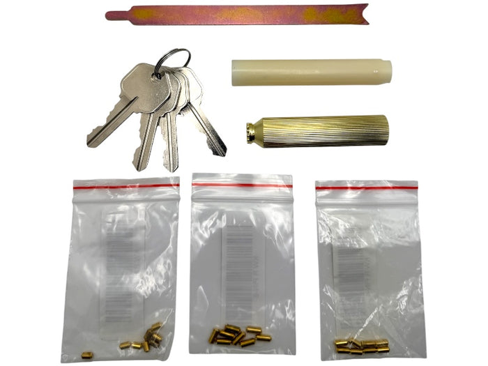 Collection of keys, cylindrical objects, and small metal parts on a white background