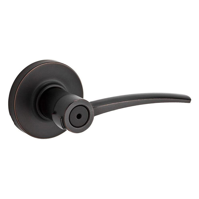 A Kwikset Katara Venetian Bronze Privacy Door Handle with a lever and round rosettes on a clear background.