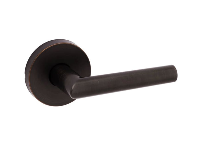 A Venetian bronze round passage door lever, part of the Kwikset Milan Collection, with a round rosette design.
