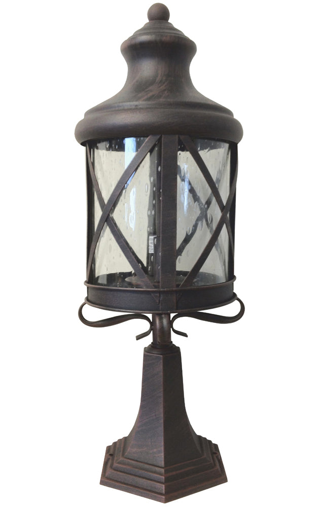 A rusted finish outdoor die cast pier mounted aluminum lantern with a raindrop glass cover, featuring a dark color and a decorative base.